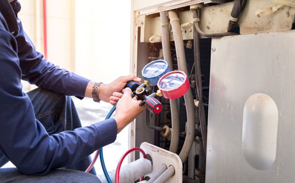 Technician tuning up an AC Unit